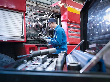 Engineer working on engine in truck repair factory Photographie de stock - Premium Libres de Droits, Code: 649-07585614