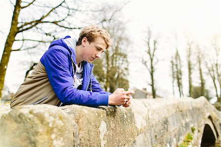 Unhappy teenage boy leaning over rural bridge Foto de stock - Sin royalties Premium, Código: 649-07585747