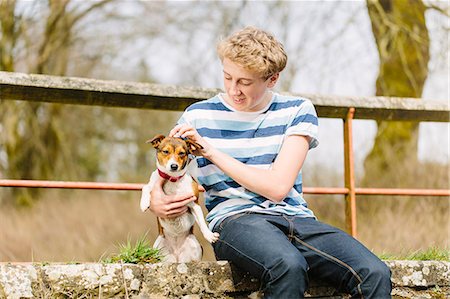 Teenage boy sitting on footbridge with his jack russell dog Stock Photo - Premium Royalty-Free, Code: 649-07585760