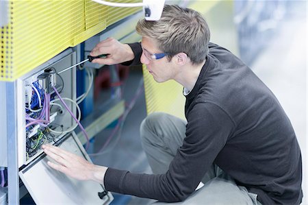 Mid adult male technician maintaining equipment in engineering plant Stock Photo - Premium Royalty-Free, Code: 649-07585771