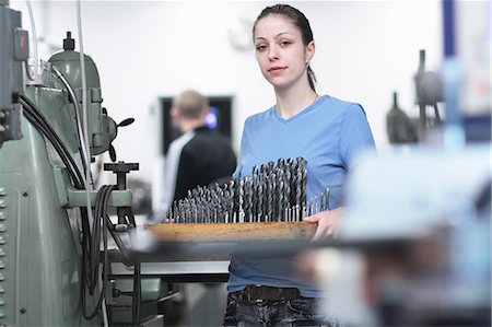 portrait woman focused - Portrait of female engineer holding a tray of drillbits Stock Photo - Premium Royalty-Free, Code: 649-07596121