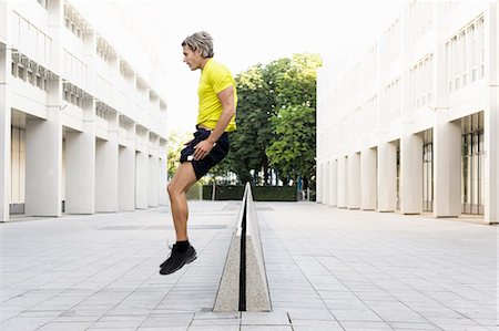 Mature man jumping over divider Stock Photo - Premium Royalty-Free, Code: 649-07596167