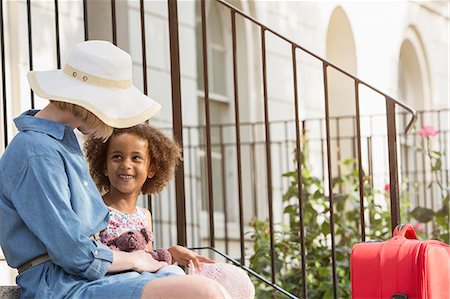 simsearch:649-07436508,k - Mother and daughter sitting outside house with suitcase Photographie de stock - Premium Libres de Droits, Code: 649-07596174