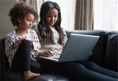 simsearch:649-08901706,k - Two sisters sitting on sofa using laptop Foto de stock - Royalty Free Premium, Número: 649-07596198