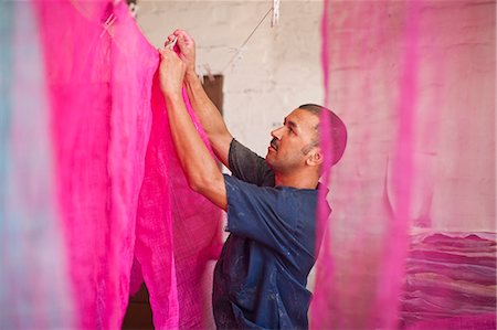 dye - Man hanging up dyed fabric in traditional milliners workshop Stock Photo - Premium Royalty-Free, Code: 649-07596216