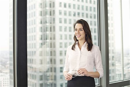 Portrait of young businesswoman in high rise office Foto de stock - Sin royalties Premium, Código: 649-07596252