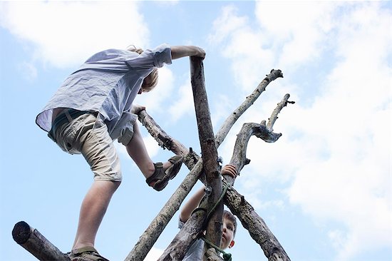 Boys climbing branch structure Photographie de stock - Premium Libres de Droits, Le code de l’image : 649-07596282