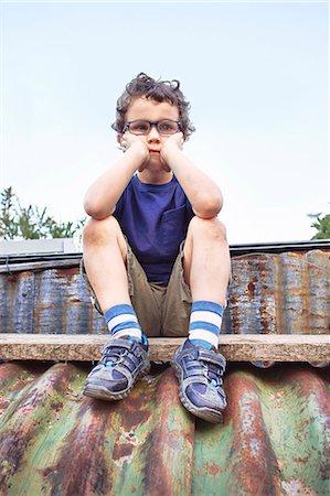 single boy lonely - Glum little boy sitting on roof Stock Photo - Premium Royalty-Free, Code: 649-07596283