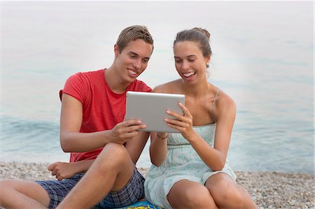 simsearch:649-07596302,k - Brother and sister sitting on beach, using digital tablet Stock Photo - Premium Royalty-Free, Code: 649-07596302