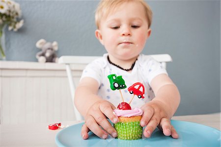 Baby boy playing with cupcake Stock Photo - Premium Royalty-Free, Code: 649-07596604