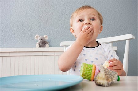 Baby boy eating cupcake Stock Photo - Premium Royalty-Free, Code: 649-07596606