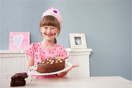 Girl showing off her birthday cake Foto de stock - Royalty Free Premium, Número: 649-07596608