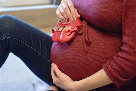 simsearch:649-07437409,k - Pregnant woman holding baby shoes to her bump Stock Photo - Premium Royalty-Free, Code: 649-07596656