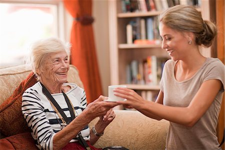 senior health care - Care assistant handing coffee cup to senior woman Stock Photo - Premium Royalty-Free, Code: 649-07596665