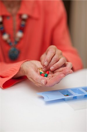 Close up of senior woman holding medication from pillbox Stock Photo - Premium Royalty-Free, Code: 649-07596667