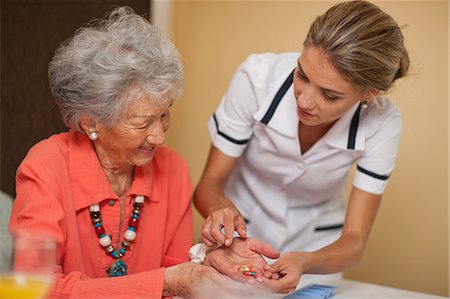 Care assistant handing medication to senior woman Stock Photo - Premium Royalty-Free, Code: 649-07596668