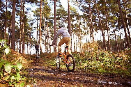 simsearch:649-07596718,k - Twin brothers racing BMX bikes in muddy forest Photographie de stock - Premium Libres de Droits, Code: 649-07596734