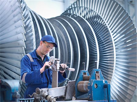 Engineer at workstation in front of steam turbine Stock Photo - Premium Royalty-Free, Code: 649-07596744