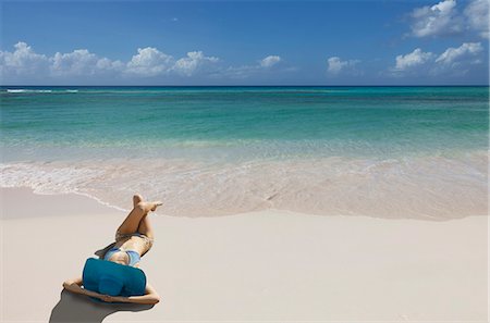 Young woman relaxing on beach with blue sunhat Foto de stock - Sin royalties Premium, Código: 649-07596785