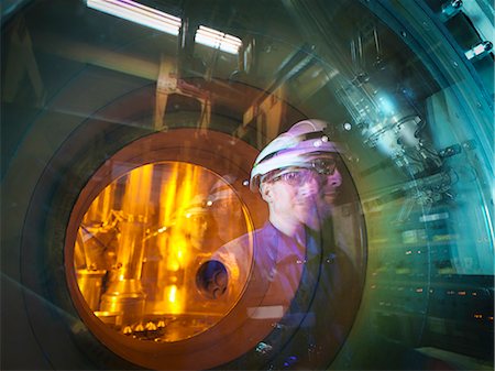 engineer (male) - Engineer reflected in glass of fuel rod handling machine in nuclear power station Stock Photo - Premium Royalty-Free, Code: 649-07647796
