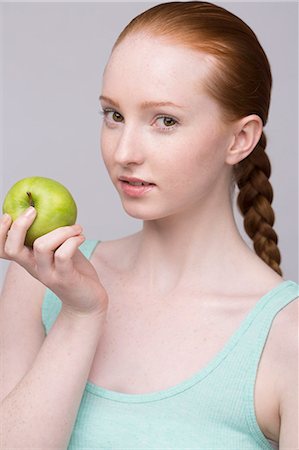 simsearch:649-07647906,k - Portrait of young woman, holding green apple Foto de stock - Sin royalties Premium, Código: 649-07647879