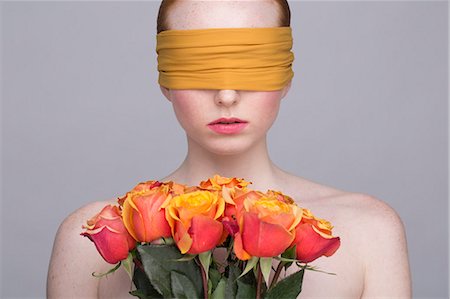 portrait woman surprise studio - Portrait of young woman, eyes covered, holding bunch of roses Stock Photo - Premium Royalty-Free, Code: 649-07647888