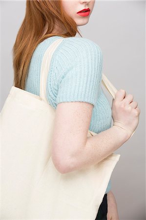 studio shot teens - Cropped image of young woman carrying shopping bag Stock Photo - Premium Royalty-Free, Code: 649-07647893