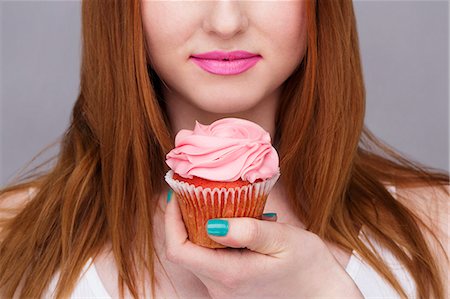 petit gâteau - Cropped image of young woman holding cupcake Photographie de stock - Premium Libres de Droits, Code: 649-07647900