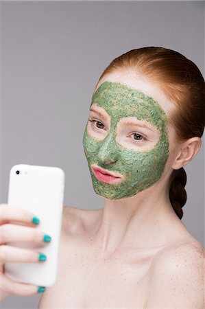 simsearch:649-07647894,k - Young woman wearing face mask, taking self portrait photograph with smartphone Foto de stock - Sin royalties Premium, Código: 649-07647912