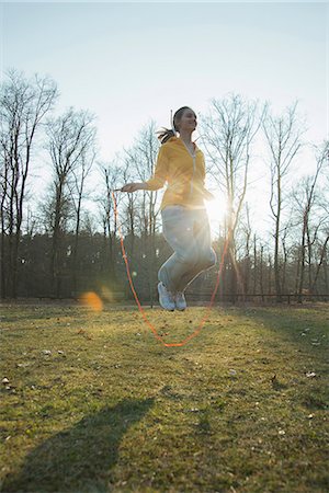 Young woman exercising in field with skipping ropes Foto de stock - Sin royalties Premium, Código: 649-07648096