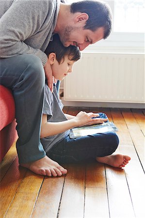 sitting on floor - Father and son using digital tablet Stock Photo - Premium Royalty-Free, Code: 649-07648109