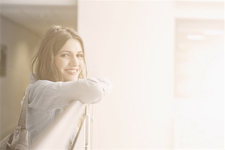 Young woman leaning on railing, portrait Stock Photo - Premium Royalty-Free, Code: 649-07648126