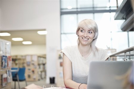 simsearch:649-07648135,k - Young woman using laptop in library Foto de stock - Royalty Free Premium, Número: 649-07648131