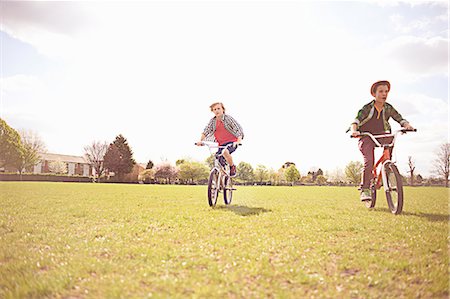 Boys cycling on playing field Foto de stock - Sin royalties Premium, Código: 649-07648166