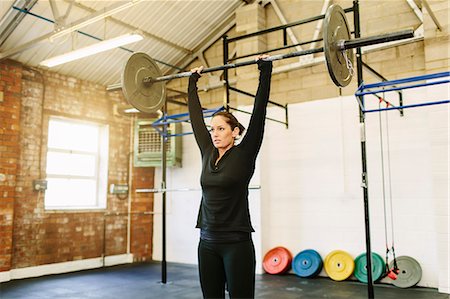 dumb bell in a gym - Woman lifting barbell in gym Stock Photo - Premium Royalty-Free, Code: 649-07648176