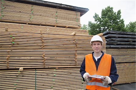 simsearch:693-05552726,k - Portrait of young male worker with clipboard in timber yard Photographie de stock - Premium Libres de Droits, Code: 649-07648216