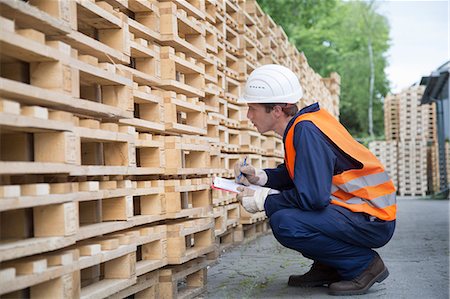 row of monitors - Young male worker pallet stock taking in timber yard Stock Photo - Premium Royalty-Free, Code: 649-07648217