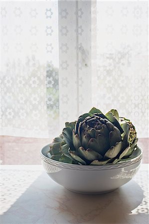 Artichoke in a bowl on sunlit windowsill Foto de stock - Sin royalties Premium, Código: 649-07648232