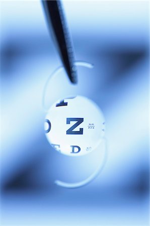 pinzette - Snellen eye chart seen through an intraocular lens. Intraocular lens is artificial and surgically implanted in the human eye following extraction of the natural crystalline lens clouded by cataract. Fotografie stock - Premium Royalty-Free, Codice: 649-07648274