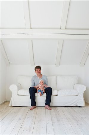 father sitting with daughter on sofa - Portrait of mature father with baby daughter on sofa Photographie de stock - Premium Libres de Droits, Code: 649-07648282