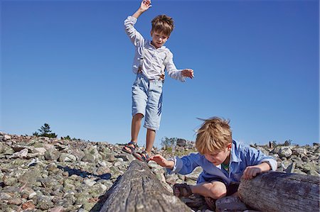 falling - Two boys playing on driftwood on beach Stock Photo - Premium Royalty-Free, Code: 649-07648395
