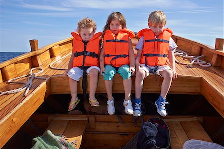 Three children sitting in boat Foto de stock - Sin royalties Premium, Código: 649-07648399