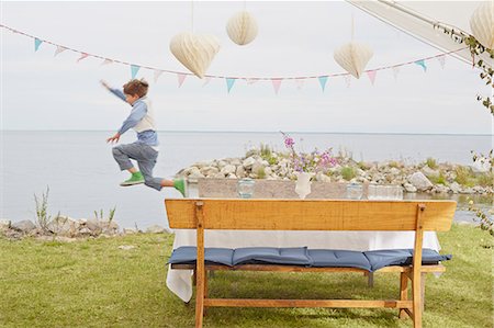 playing (recreation) - Young boy jumping mid air at party Stock Photo - Premium Royalty-Free, Code: 649-07648439