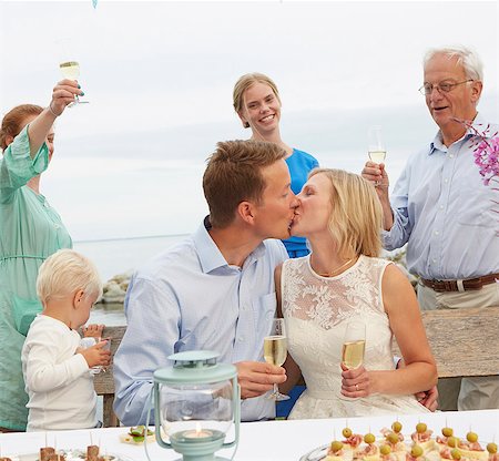 simsearch:6113-06625675,k - Mid adult couple kissing and making a toast with group of friends Photographie de stock - Premium Libres de Droits, Code: 649-07648440