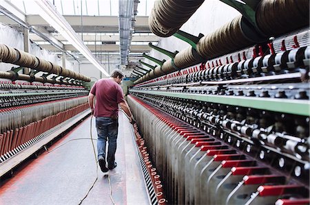 Male factory worker monitoring weaving machines in woollen mill Fotografie stock - Premium Royalty-Free, Codice: 649-07648499
