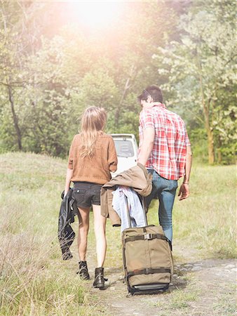 Young couple with wheeled suitcase heading for pick-up truck, Piemonte, Italy Stock Photo - Premium Royalty-Free, Code: 649-07648491