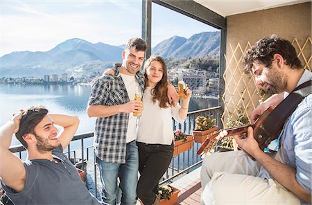 Four friends on balcony, with guitar and beer Photographie de stock - Premium Libres de Droits, Code: 649-07648565