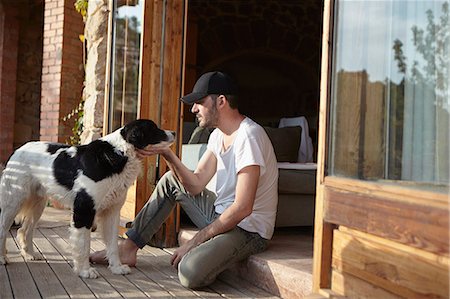 patio door - Mid adult man petting dog on patio Stock Photo - Premium Royalty-Free, Code: 649-07648598