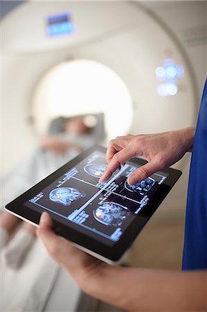 diagnostique - Radiographer looking at brain scan image on digital tablet Foto de stock - Sin royalties Premium, Código: 649-07709925