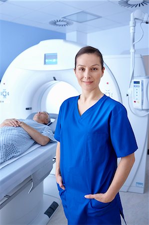 radiology patient - Radiographer standing in front of man going into CT scanner Photographie de stock - Premium Libres de Droits, Code: 649-07709920